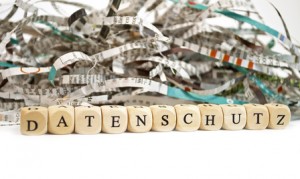 Geschredderte Papierstreifen und darunter der Schriftzug Datenschutz