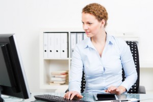 Eine Frau sitzt am PC und recherchiert im Internet